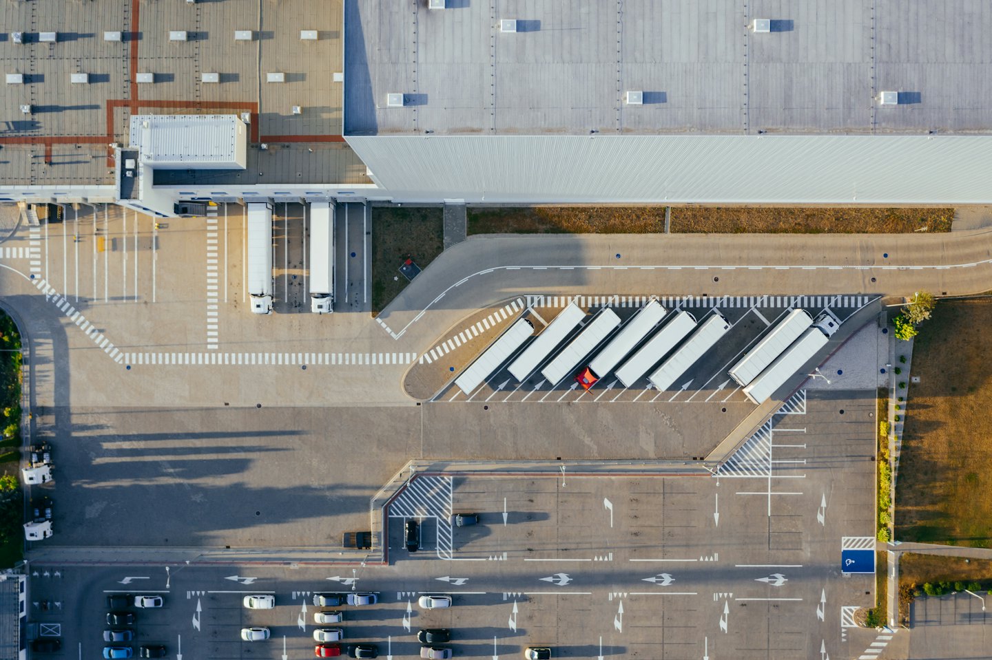 Sattelzüge an einer belebten Laderampe eines Logistiklagers.