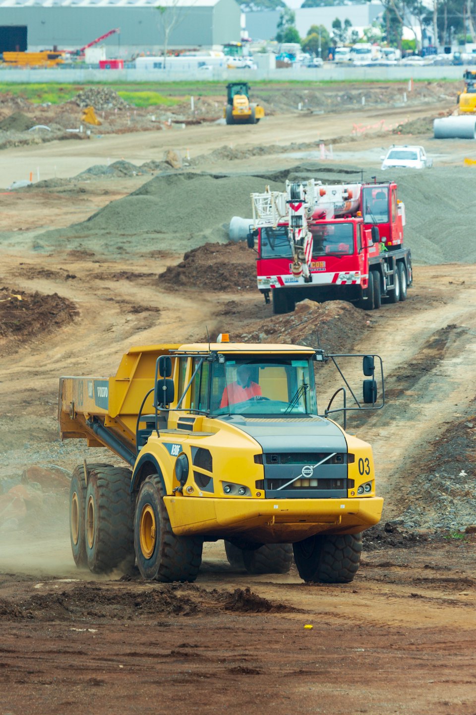 Gelber Volvo-Muldenkipper fährt auf einer Baustelle.