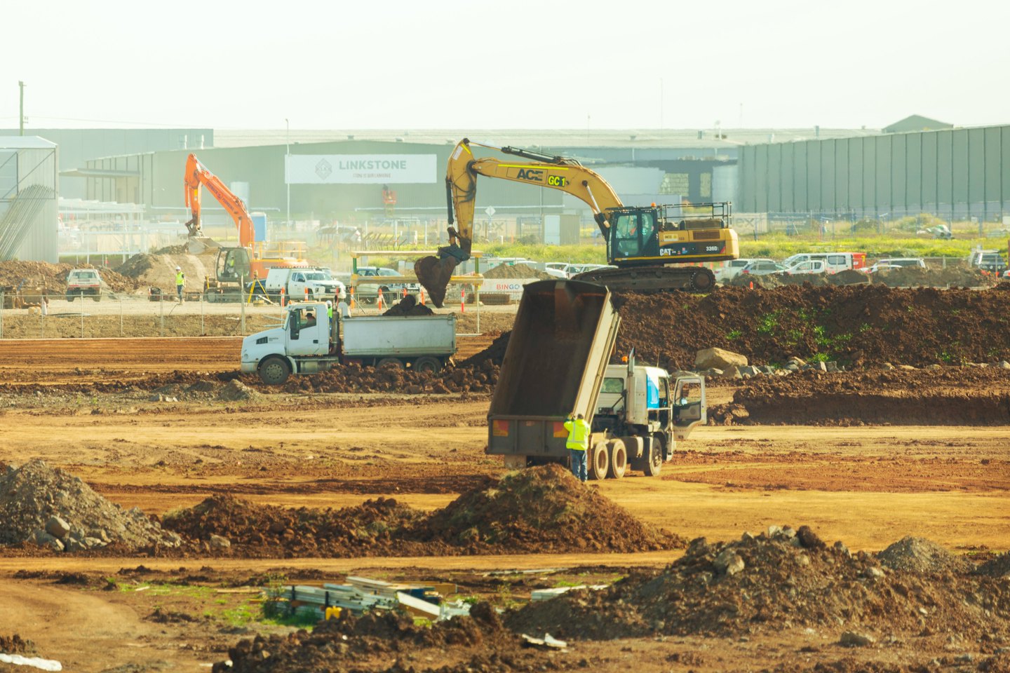 Bagger lädt Erde auf einen Muldenkipper auf einer Baustelle.